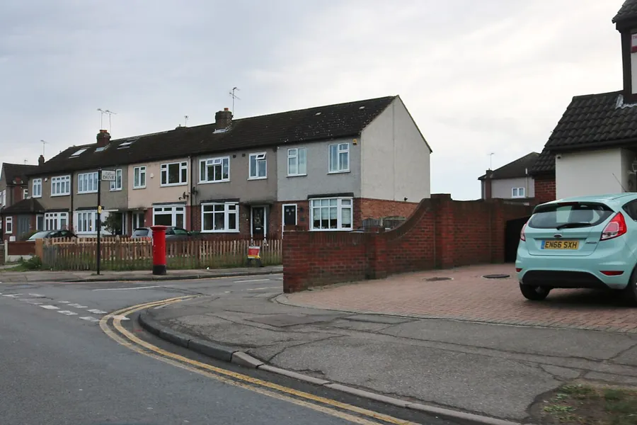 Terraced houses on Front Lane in Cranham with low front walls and a block paved parking area