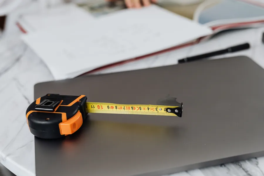 Tape measure resting on paperwork, the kind of measuring up that goes into a written driveway quote